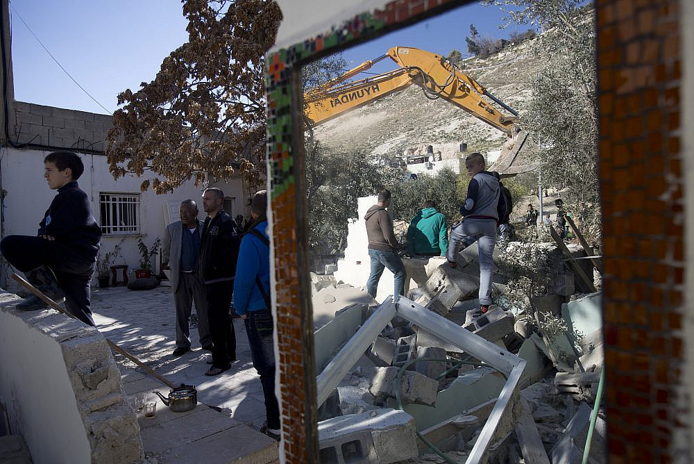 The Mezri family demolish their own home in Jabel Mukaber after learning that they would be forced to pay the Israeli authorities for carrying out the destruction, East Jerusalem, February 5, 2014. (Tali Mayer/Activestills.org)