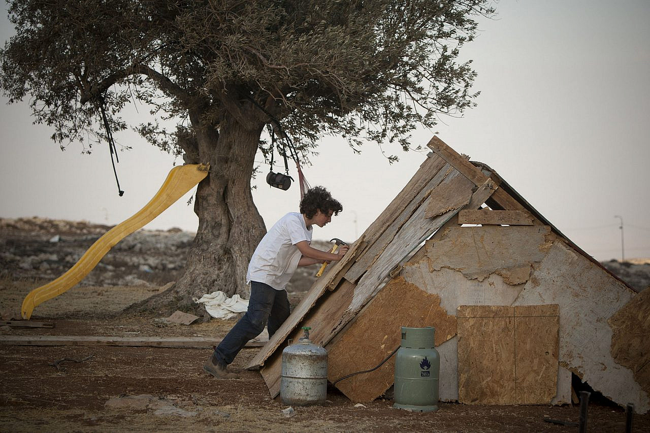 An Israeli settler builds a cabin on a hill in the illegal outpost of Ramat Migron, near Ramallah in the occupied West Bank, August 29, 2011. (Yonatan Sindel/Flash90)
