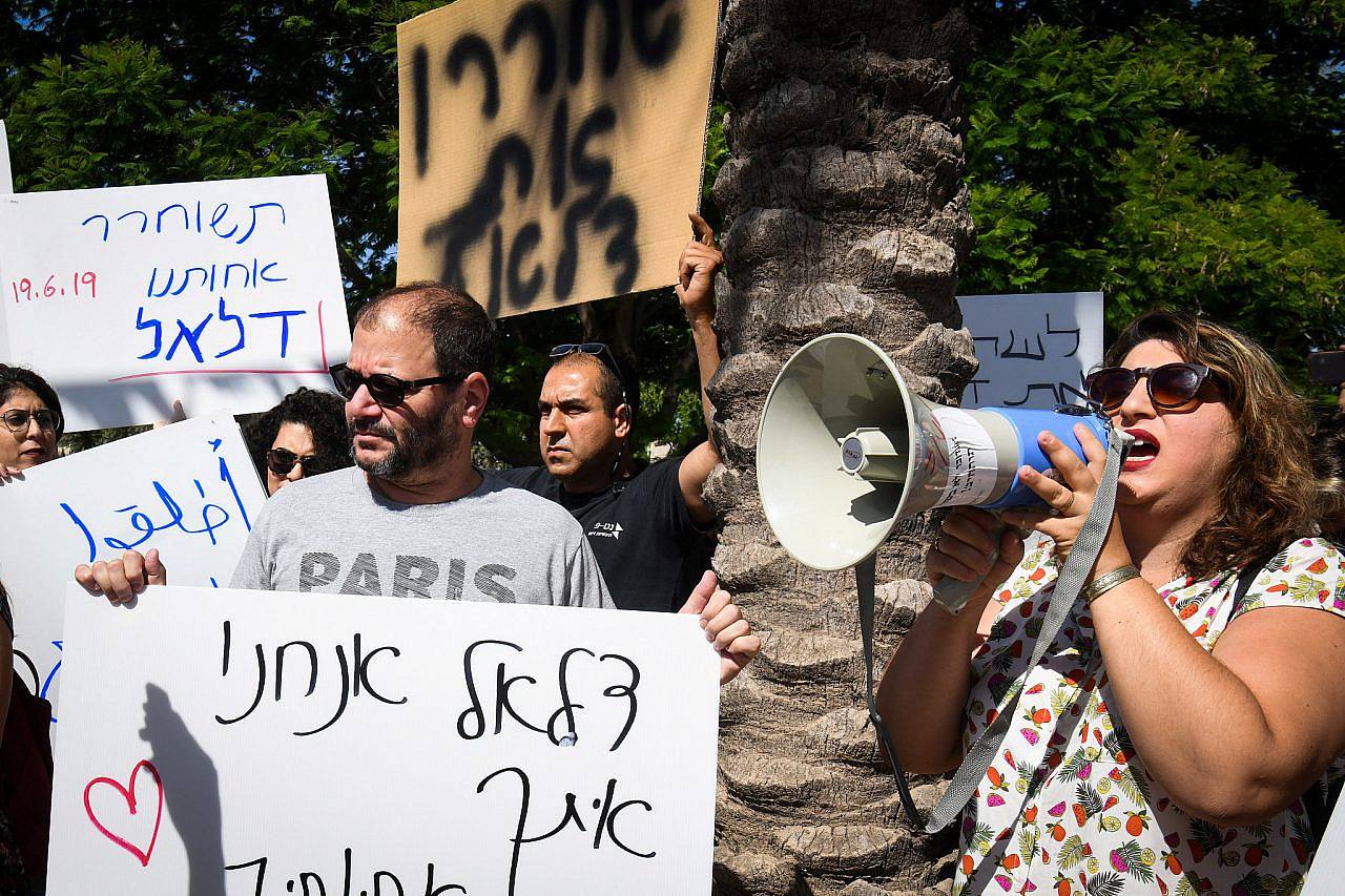 Sapir Sluzker Amran speaks through a megaphone at a protest for the release of Dalal Daoud from prison, Ramla, June 19, 2019. (Avi Dishi/Flash90)