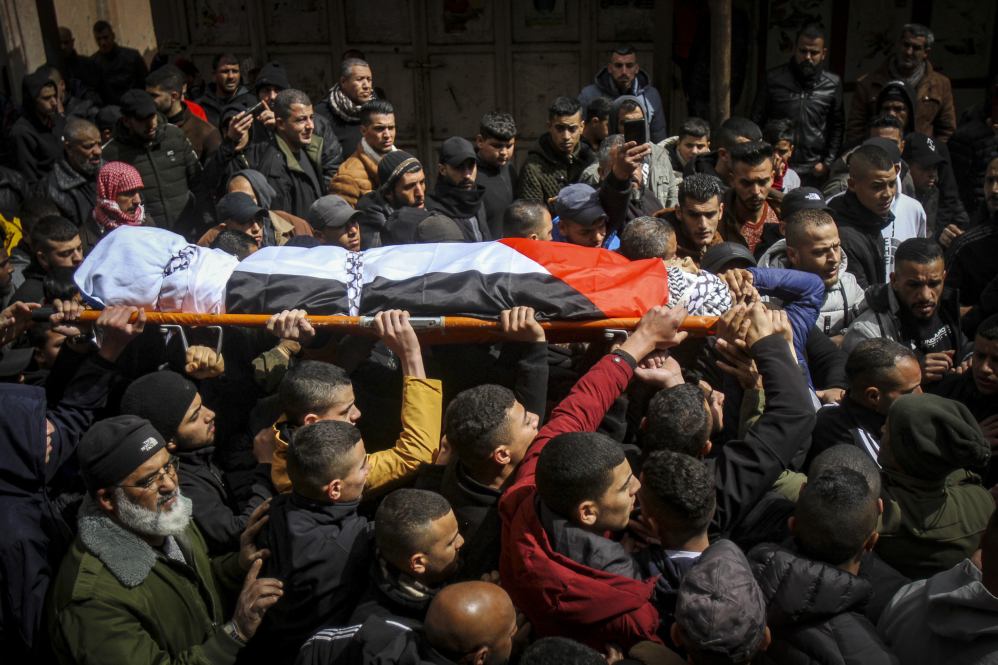 Mourners carry the body of 16-year-old Nader Rayan during his funeral at Balata refugee camp in the West Bank city of Nablus, March 15, 2022. (Nasser Ishtayeh/Flash90)
