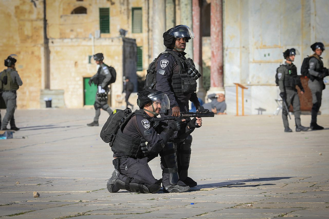 Israeli police officers fire tear gas at Palestinian worshippers, some of who threw at them, at Al-Aqsa compound in Jerusalem's Old City, April 15, 2022. (Jamal Awad/Flash90)