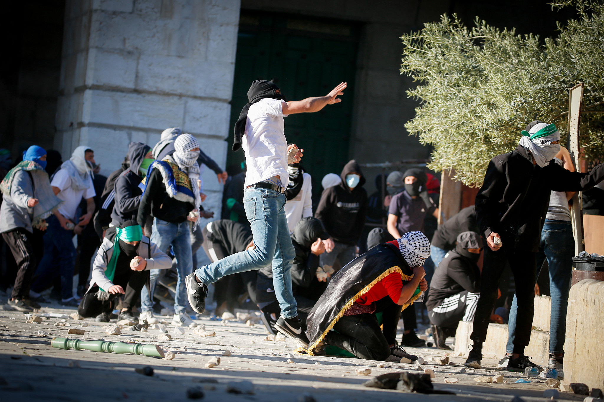 Palestinian protesters hurl stones toward Israeli security forces during clashes on the holy month of Ramadan at Al-Aqsa Mosque compound in Jerusalem's Old City, April 15, 2022. (Jamal Awad/Flash90)