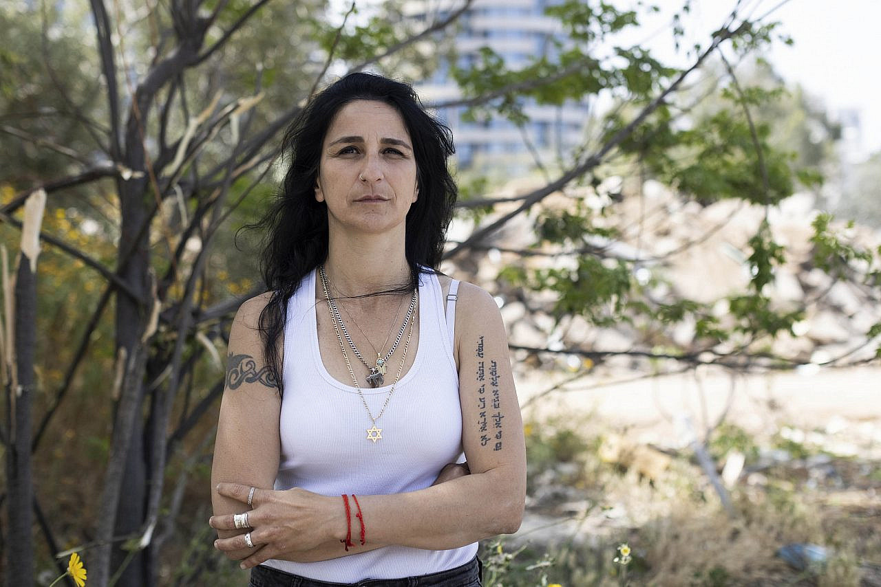 Carmen Elmakiyes Amos, co-founder of the Shovrot Kirot movement, stands in front of the ruins of the Givat Amal neighborhood in north Tel Aviv, April 11, 2022. (Oren Ziv)