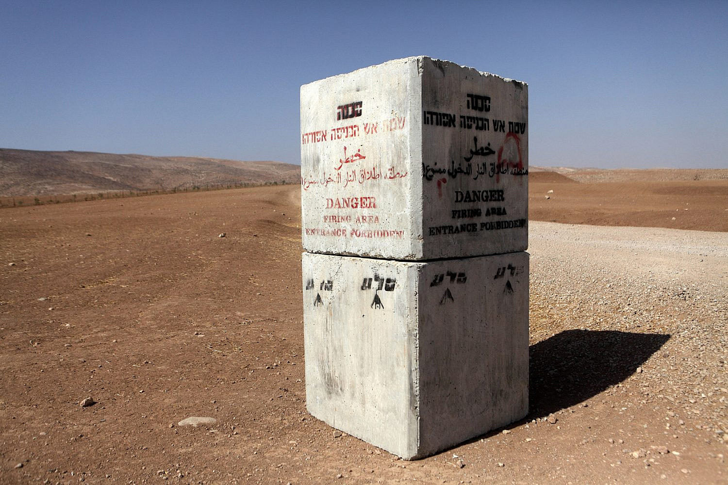 An Israeli military "firing zone" warning sign near the West Bank village of Jinba, located in the South Hebron Hills, September 6, 2012. (Anne Paq/Activestills)