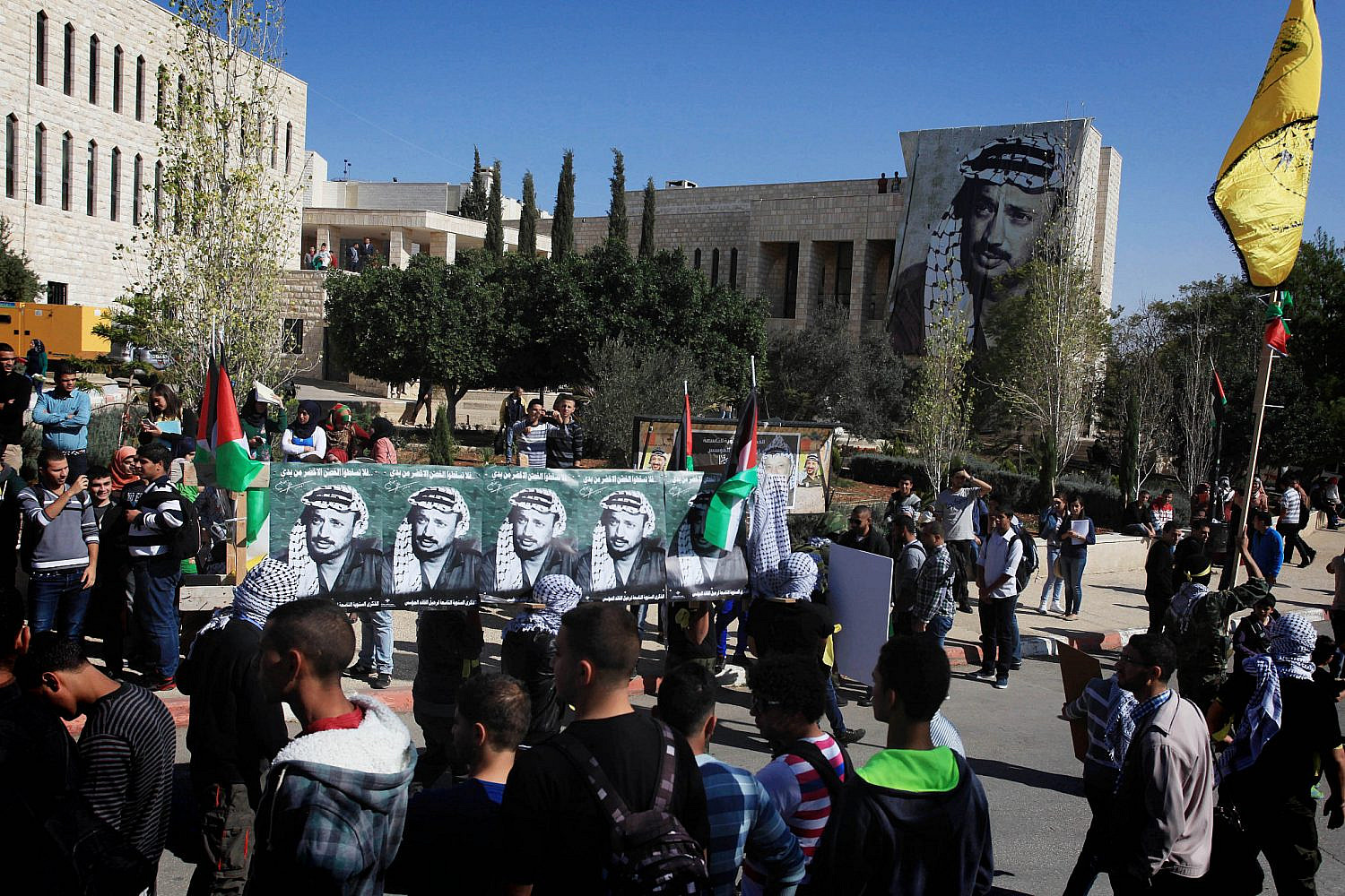 Palestinian university students march during a ceremony marking the 9th anniversary of Yasser Arafat's death, at the Birzeit University campus, near the West Bank city of Ramallah, November 11, 2013. (Issam Rimawi/Flash90)