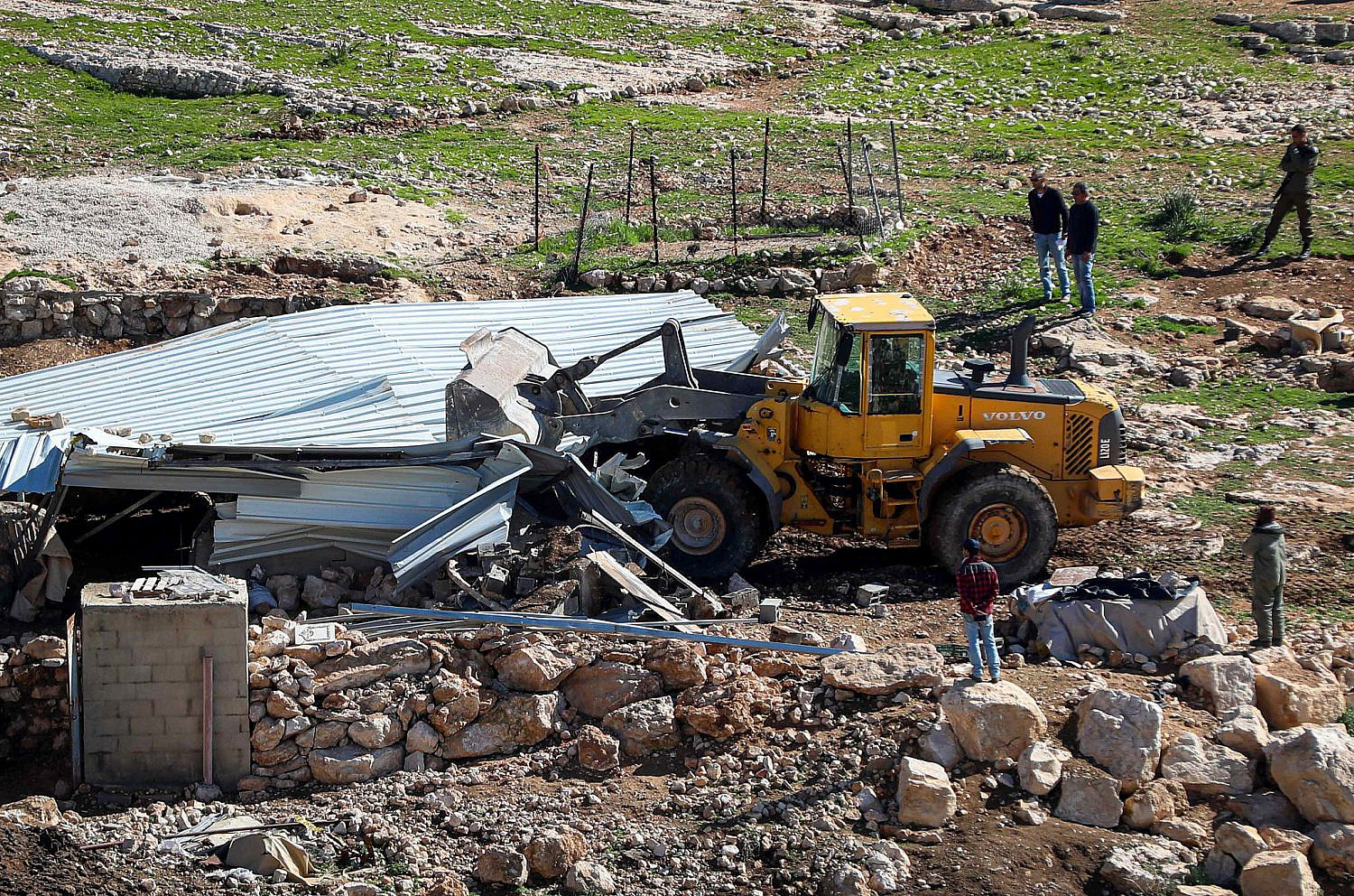 An Israeli bulldozer demolishes a Palestinian farm shed in the West Bank area of Masafer Yatta, February 27, 2020. (Wisam Hashlamoun/Flash90)