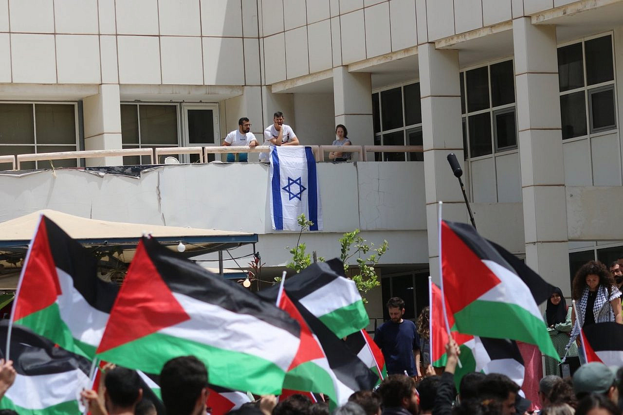 Palestinian students wave flags at the Nakba Day ceremony at Tel Aviv University, May 15, 2022. (Activestills)
