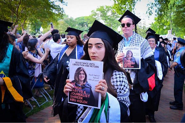 Nooran Alhamdan, along with other students at Georgetown University, hold up photos of slain Palestinian journalist Shireen Abu Akleh to protest U.S. Secretary of State Antony Blinken's commencement speech at their graduation ceremony, May 21, 2022. (Kannithi Traitonwong)