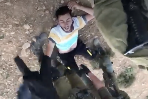 Israeli soldiers pummel and beat +972 and Local Call journalist Basil al-Adraa in his home village of A-Tuwani. (Sami Hureini)