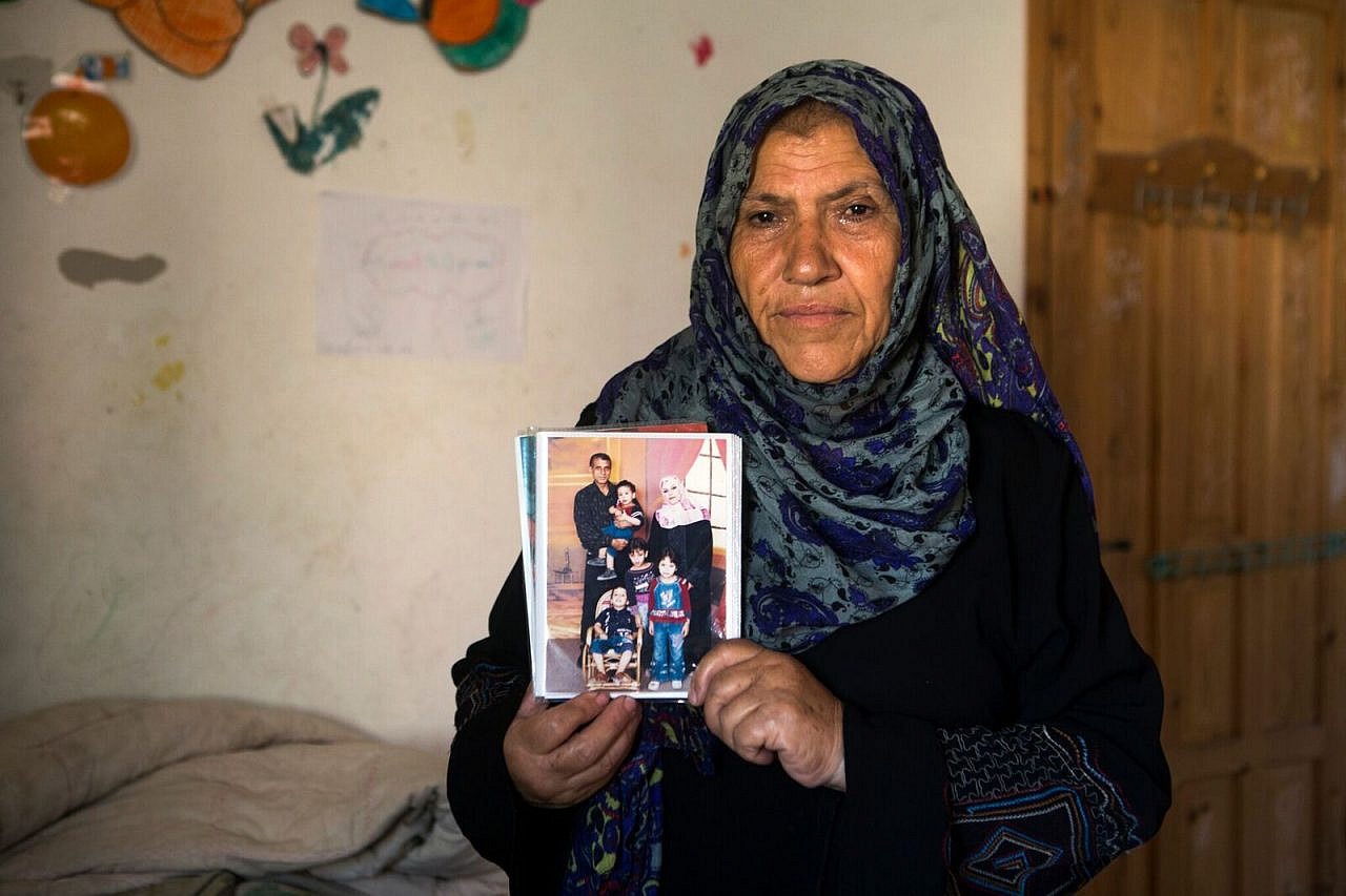 Khadija, Ibrahim Kilani’s sister, holds a photo of her brother and his family who were killed in an Israeli air attack in Gaza in 2014. (Anne Paq/Activestills)