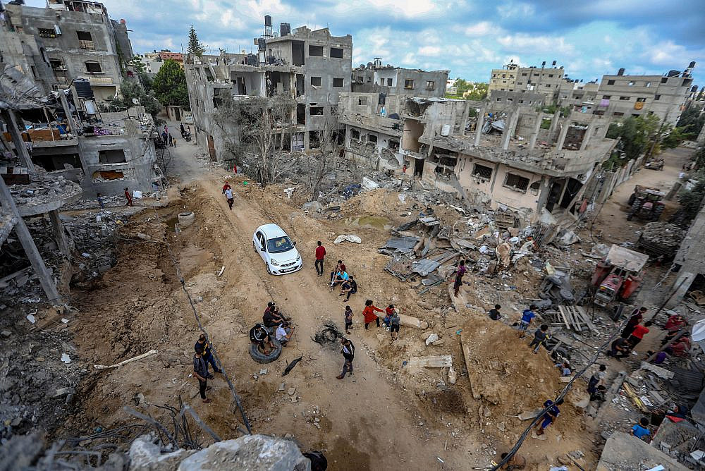 Palestinians stand amidst the ruins of a neighborhood of Beit Hanoun which was destroyed by the recent Israeli bombardements , northern Gaza Strip, May 21, 2021. (Mohammed Zaanoun/Activestills)