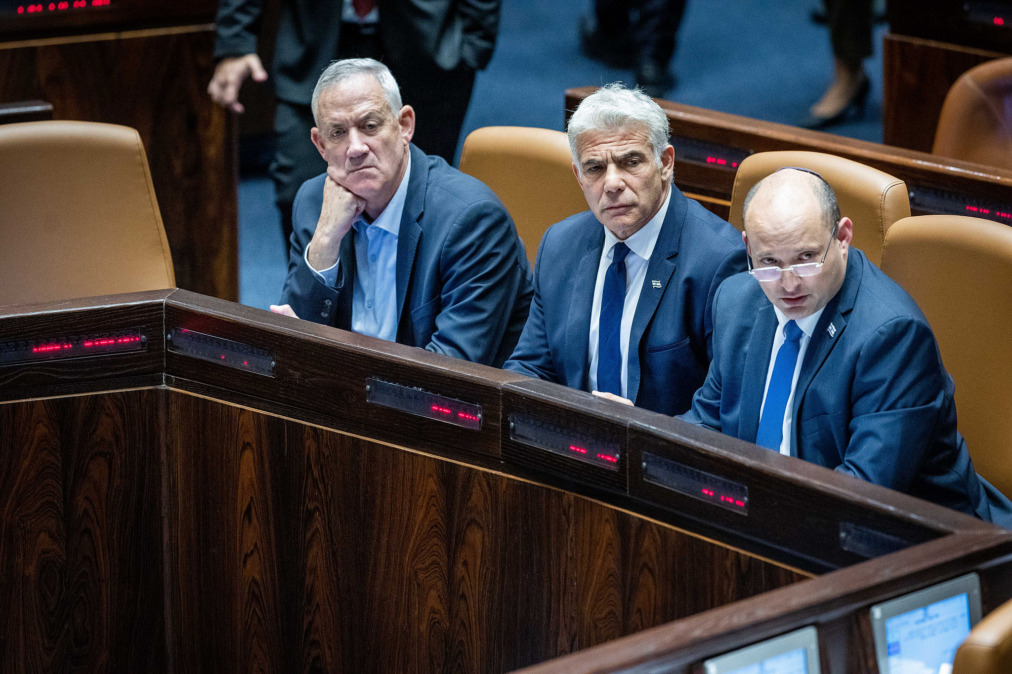 Israeli Prime Minister Naftali Bennett, Minister of Foreign Affairs Yair Lapid, and Minister of Defense Benny Gantz seen during a discussion and vote on the "settler law bill" at the Knesset in Jerusalem, June 6, 2022. (Yonatan Sindel/Flash90)
