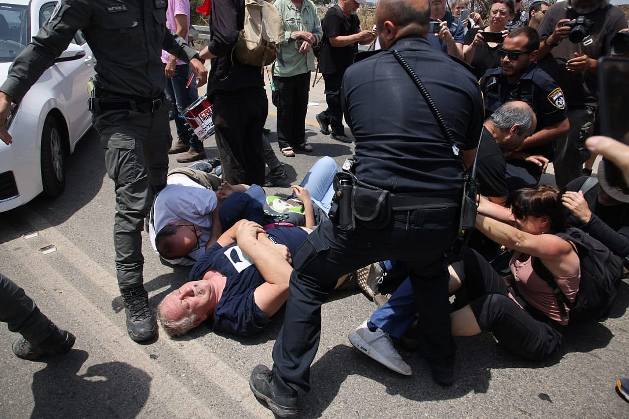 Left-wing Israeli activists lie down on the road to try to prevent a police detention, Rosh Ha'ayin, May 28, 2022. (Oren Ziv)