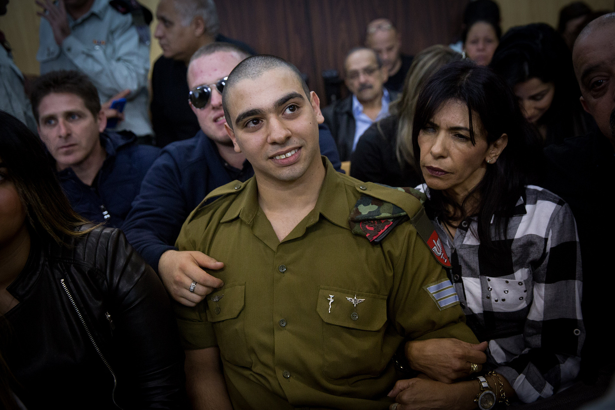 IDF Sgt. Elor Azaria, the Israeli soldier, who shot dead a disarmed and injured Palestinian attacker in the West Bank city of Hebron, is surrounded by family and friends as he awaits to hear his verdict in a courtroom at the Kirya military base in Tel Aviv, January 4, 2017. (Miriam Alster/Flash90)