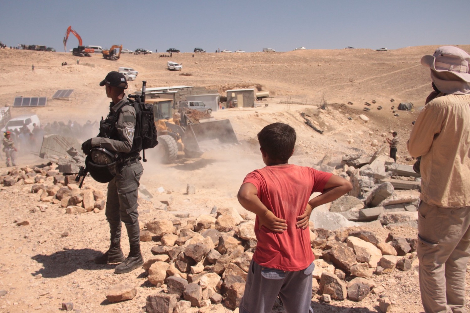 Palestinians look on as Israeli forces demolish structures in Um Qusa, Masafer Yatta, July 4, 2022. (Basil Adraa/Activestills.org)