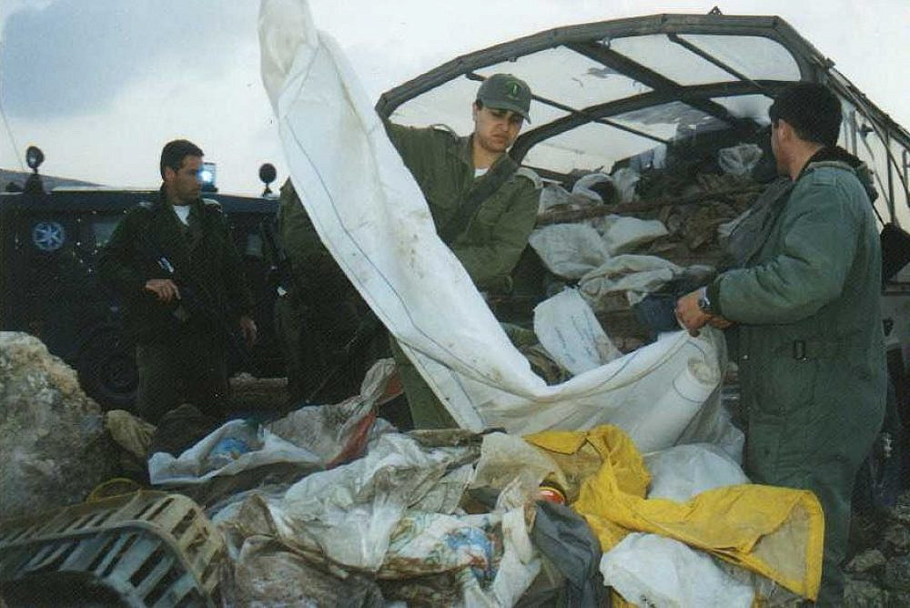 Israeli soldiers load the belonging of the Palestinian residents of Masafer Yatta onto trucks as the residents are expelled from their homes, January 1, 2000. (B'Tselem)