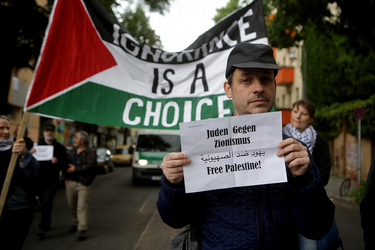 An activist holds a sign reading "Jews against Zionism, Feee Palestine" during a demonstration marking Nakba Day, Berlin, Germany, May 15, 2016. (Anne Paq/Activestills)