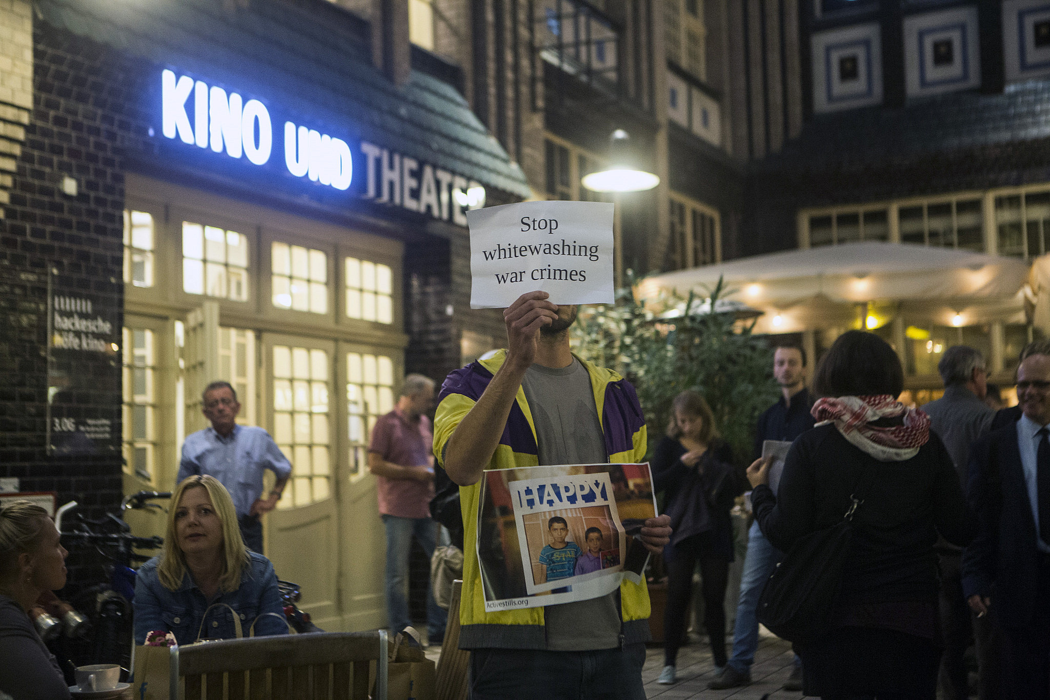 Activists hold a protest vigil in front of the Hackesche Höfe cinema for the opening of the 'Seret International' Israeli film festival, in Berlin, Germany, September 17, 2016. The activists held photos of families killed in Gaza and signs reading "culture can't hide massacres" and "stop whitewashing war crimes." (Anne Paq/Activestills)
