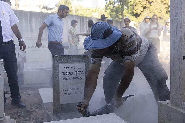 A forensic team from Israel's Health Ministry opens Yosef Melamed's grave in order to take a DNA sample, Nahalat Yitzhak Cemetery, Tel Aviv, July 27, 2022. Melamed's family, who immigrated from Yemen, believe he was kidnapped along with hundreds of children from Middle Eastern and North African countries in the 1940’s and 1950’s. (Oren Ziv)