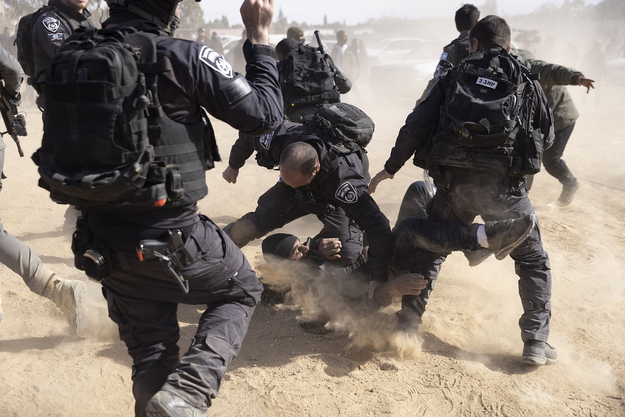 Palestinian Bedouin citizens of Israel try to stop Israeli bulldozers being used in a tree-planting program carried out by the Jewish National Fund (JNF) on the land of the village of Sa’wa al-Atrash in the Naqab/Negev, January 12, 2022. (Oren Ziv/Activestills)