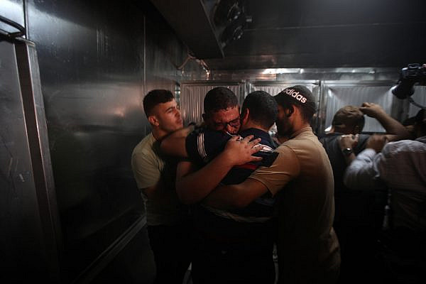 Palestinian mourners at a morgue following an Israeli air strike in Gaza, August 5, 2022. (Mohammed Zaanoun/Activestills)