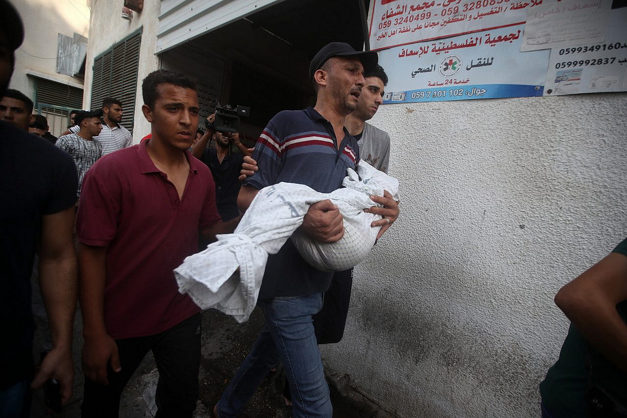 The father of Alaa Qaddoum, a five-year-old Palestinian girl, carries her body away after she was killed by an Israeli airstrike in the Shuja'iyya neighborhood of Gaza City, August 5, 2022. (Mohammed Zaanoun)