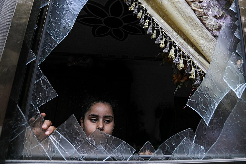 A Palestinian girl looks at the damage to a house following an Israeli airstrike in Rafah, Gaza Strip, August 8, 2022. (Abed Rahim Khatib/Flash90)