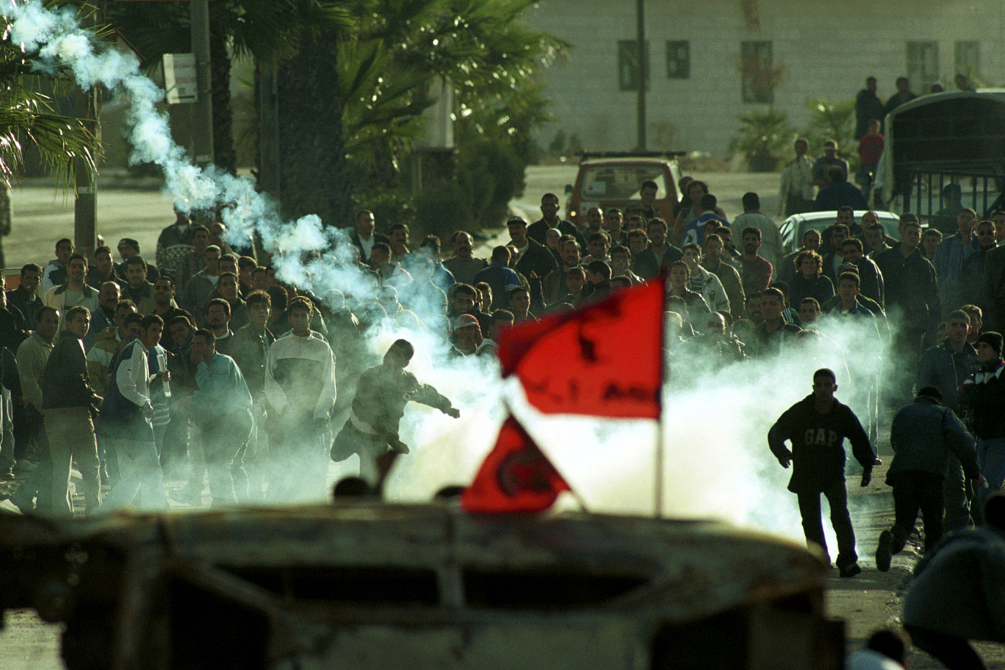 Palestinians throw back tear gas at the Israeli army in Ramallah during the first days of the Second Intifada, October 24, 2000. (Nati Shohat/Flash90)