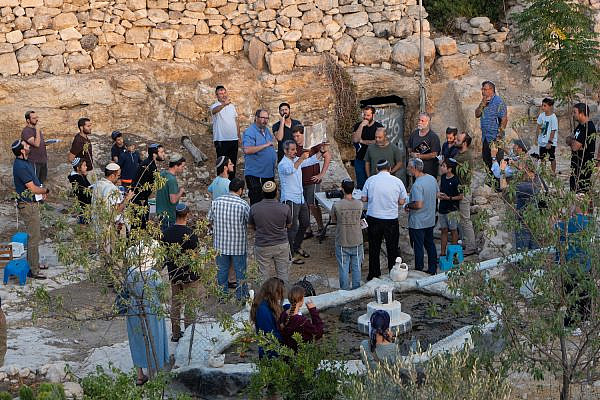 Settlers, under the guise of Israeli security forces, hold a Tisha B'av prayer service in the middle of the Palestinian village of A-Tuwani, South Hebron Hills, August 7, 2022. (Omri Eran-Vardi)