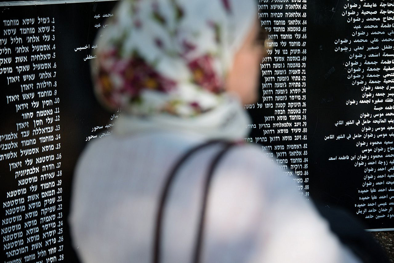 A Palestinian woman stands in front of panels bearing the names of those who died in the Deir Yassin massacre, Givat Shaul, West Jerusalem, April 10, 2014. (Activestills/Ryan Rodrick Beiler)