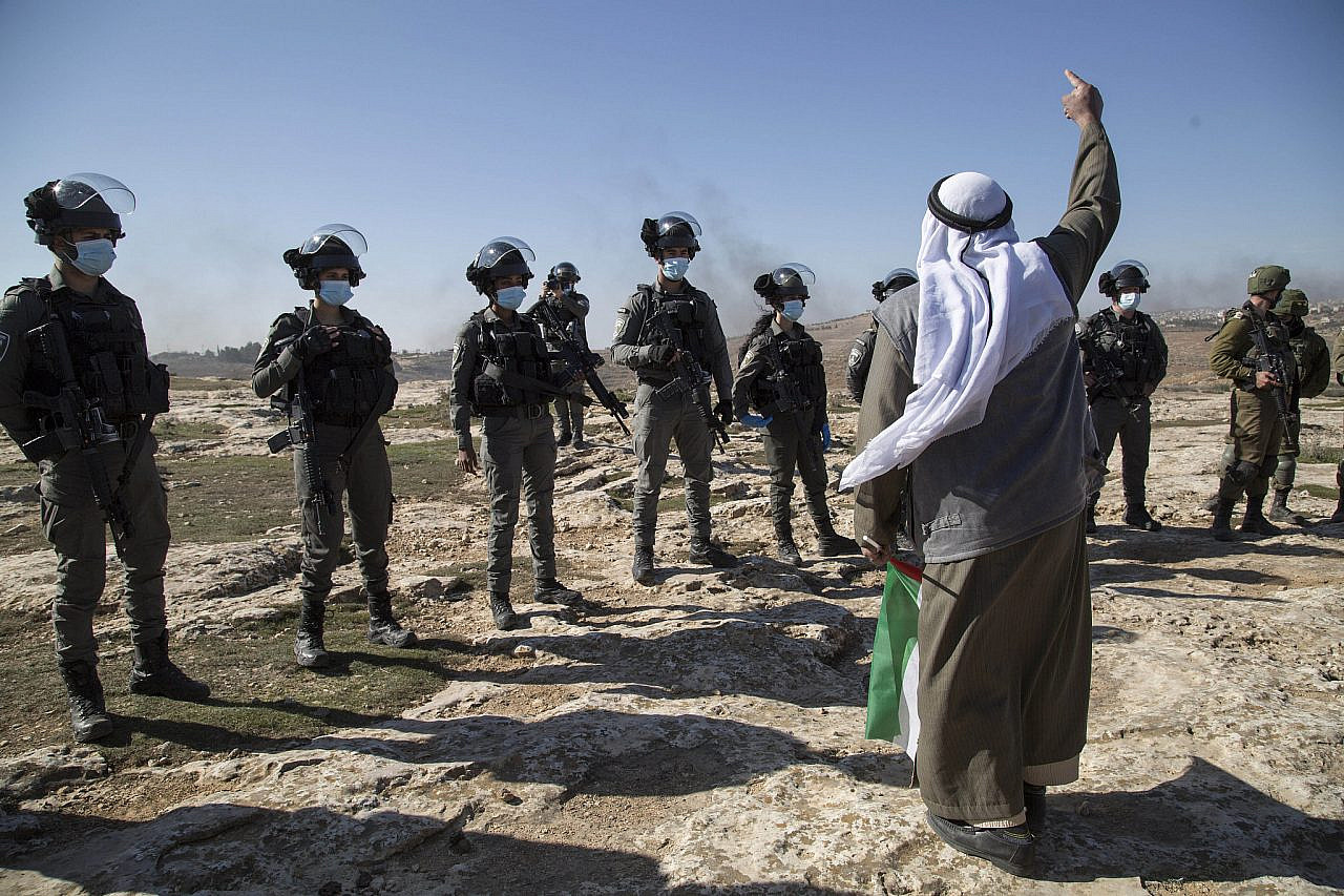An elder Palestinian man confronting Israeli Border Police soldiers during a march in A-Rakeez, Massafer Yatta area, South of Hebron, January 8, 2021. (Activestills/Keren Manor)