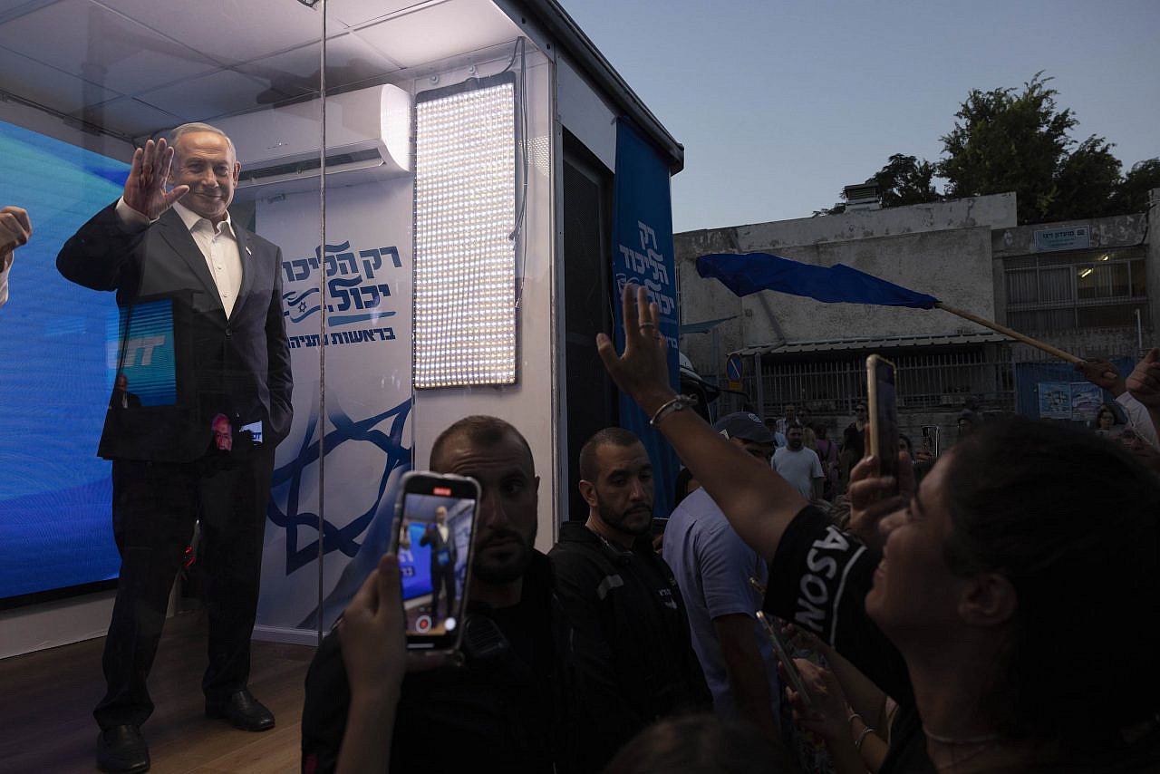 Benjamin Netanyahu seen behind bulletproof glass during an election event in south Tel Aviv, September 7, 2022. (Oren Ziv)