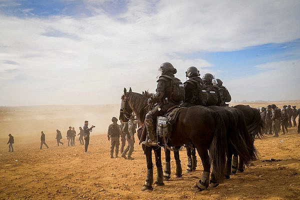 Israeli police officers guard during a protest against tree planting by the Jewish National Fund, outside the Bedouin village of Sa'wa al-Atrash in the Naqab/Negev desert, southern Israel, January 12, 2022. (Flash90)