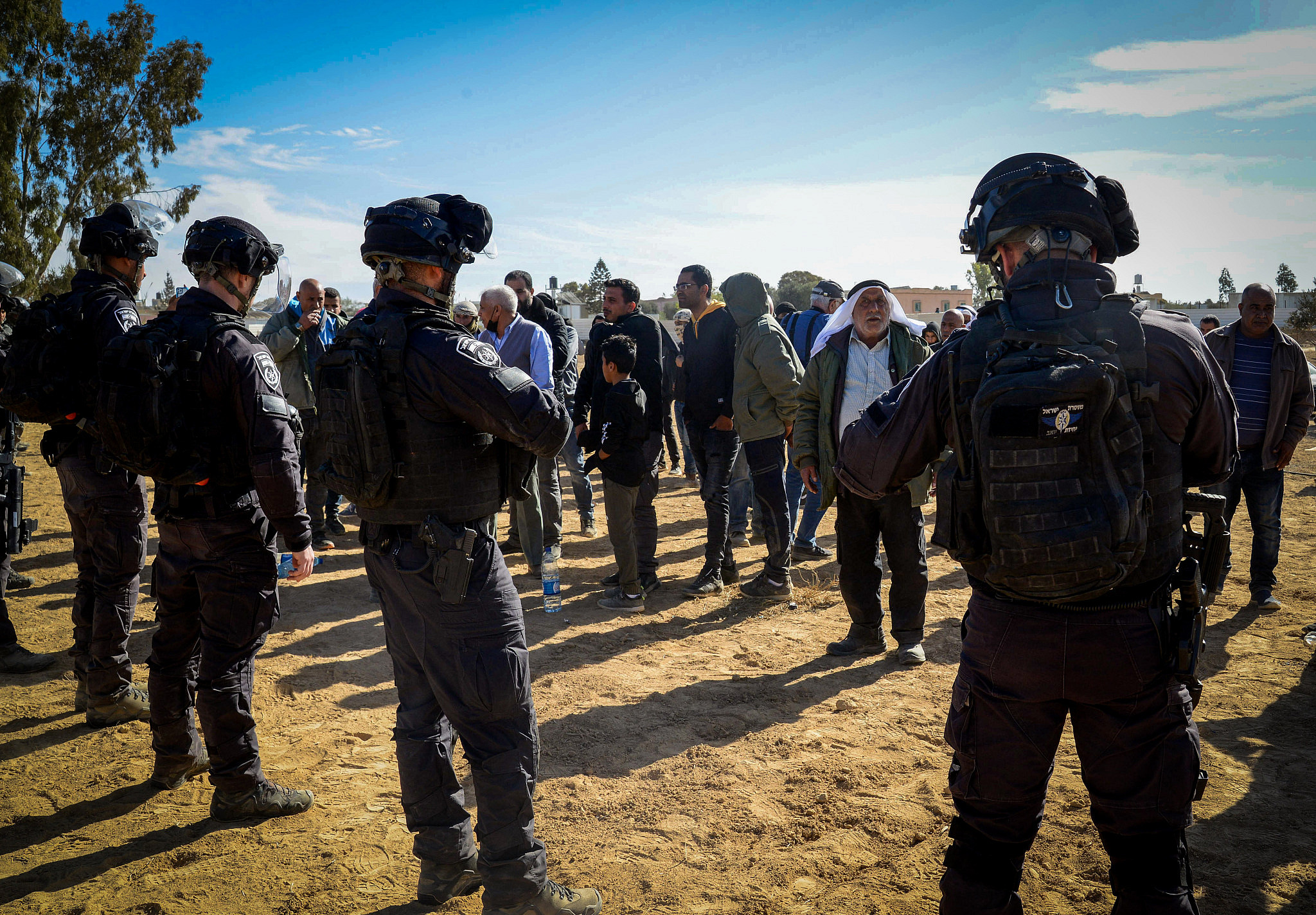 Israeli police officers clash with Bedouin citizens during a protest against tree planting by the Jewish National Fund, outside the Bedouin village of Sa'wa al-Atrash in the Naqab/Negev desert, southern Israel, January 12, 2022. (Flash90)