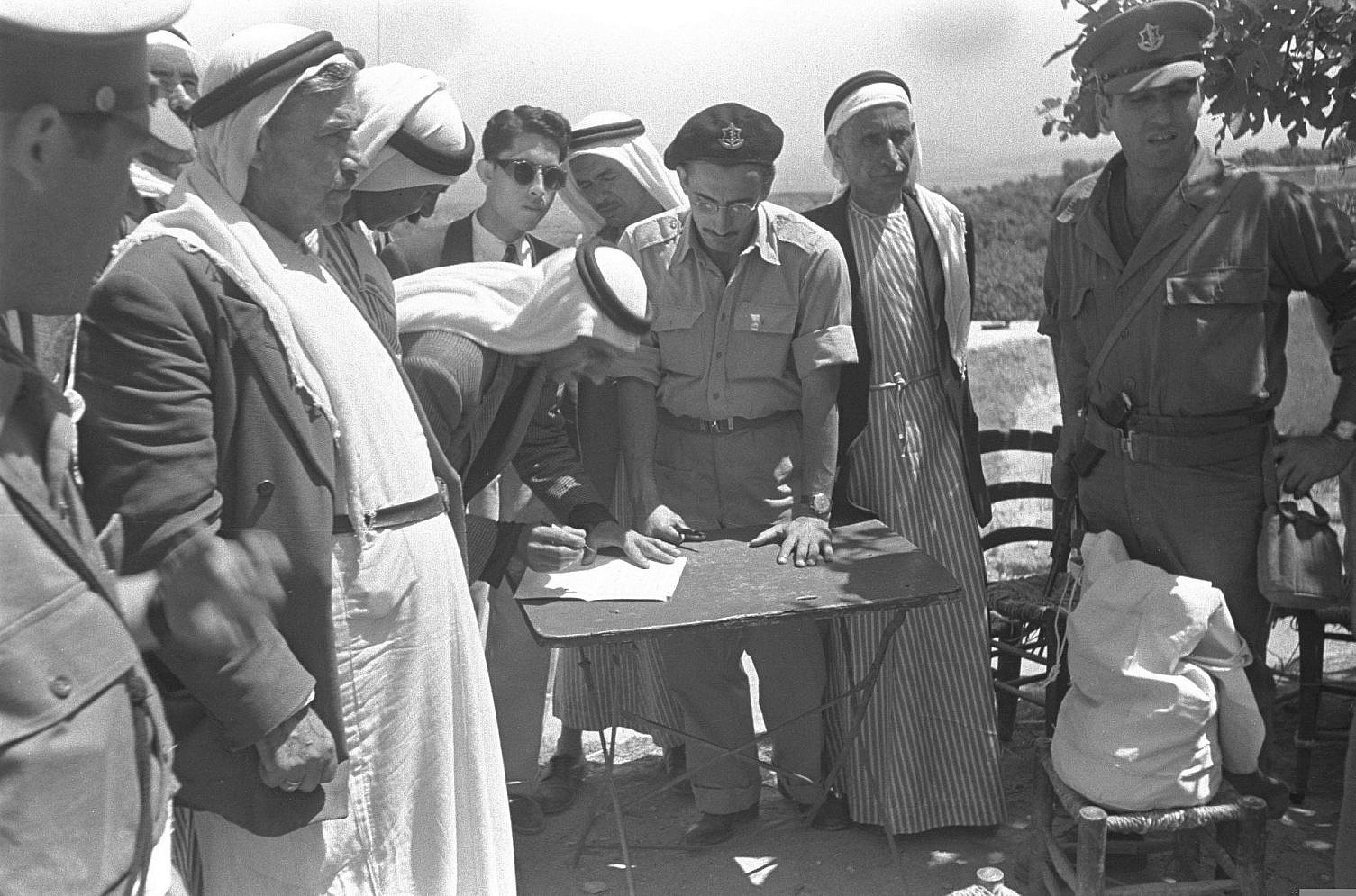 The village head of Umm el-Fahm signs an oath of allegiance in the presence of Israeli military government officials, transferring the village over to Israeli rule, May 20, 1949. (GPO)