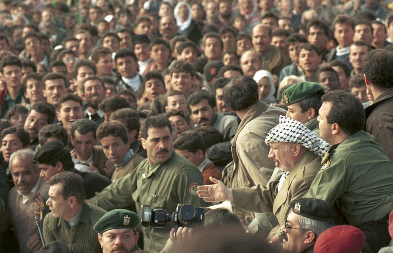 Late Palestinian President Yasser Arafat is cheered on by supporters as he visits the West Bank city of Hebron during the First Intifada, January 19, 1997. (Nati Shohat/Flash90)