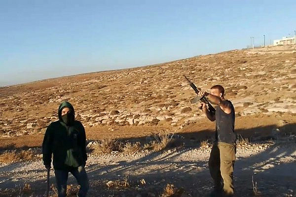 Israeli settlers armed with a rifle and metal bars confront Palestinian farmers near the village of A-Tuwani in the South Hebron Hills, occupied West Bank, September 13, 2022. (Screenshot from a video of the incident)