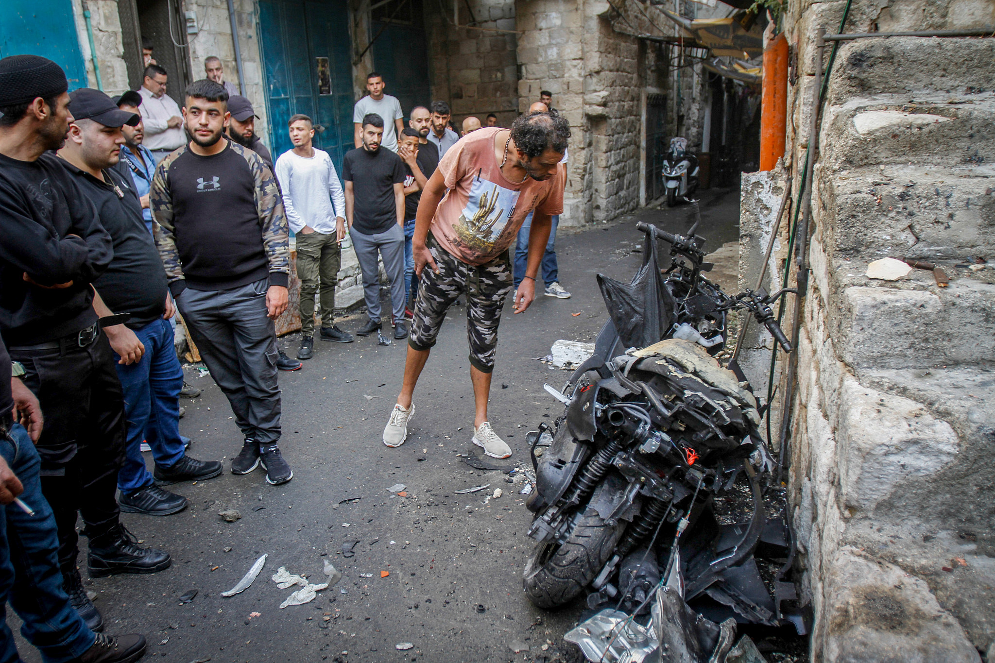 Palestinians inspect a motorbike on which Tamer El Kayani, a member of the Lions' Den who was killed in the Old City of the West Bank city of Nablus, October 23, 2022. (Nasser Ishtayeh/Flash90)
