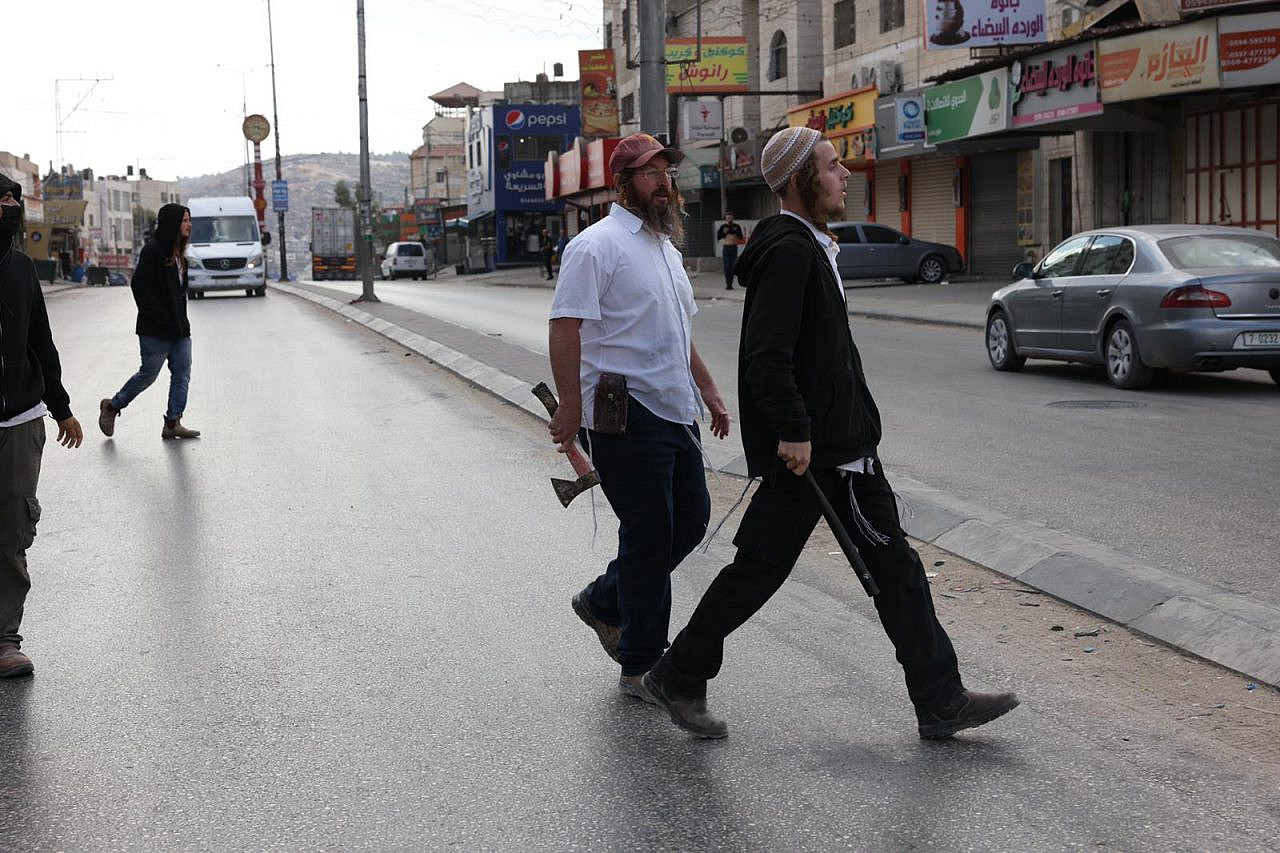 Israeli settlers armed with clubs and rocks attack Palestinians in the town of Huwara, near Nablus, occupied West Bank, October 13, 2022. (Oren Ziv)