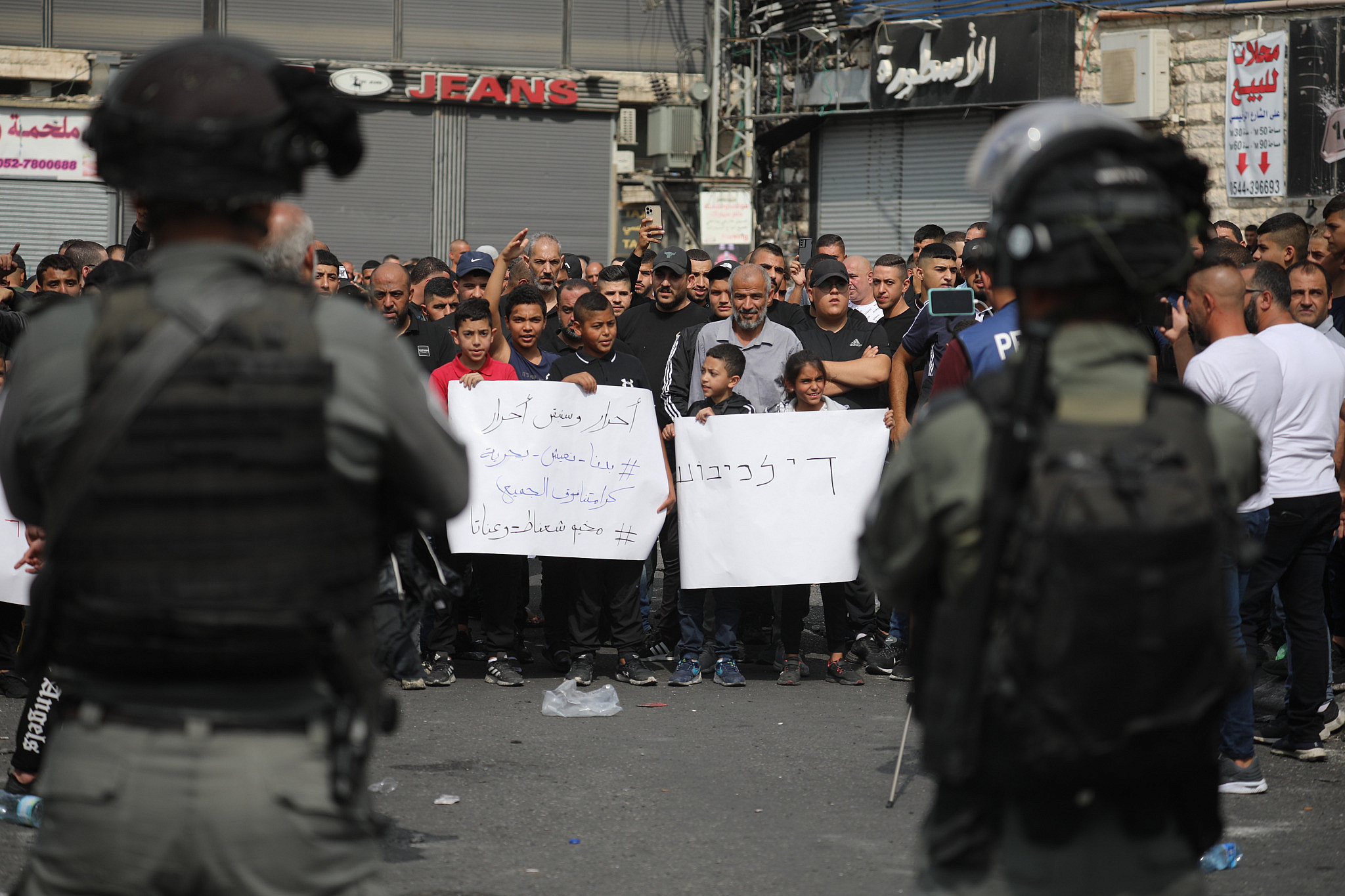 Israeli police stand opposite Palestinians in Shuafat Refugee Camp as they protest a days-long lockdown imposed by Israel, occupied East Jerusalem, October 12, 2022. (Oren Ziv/Activestills)