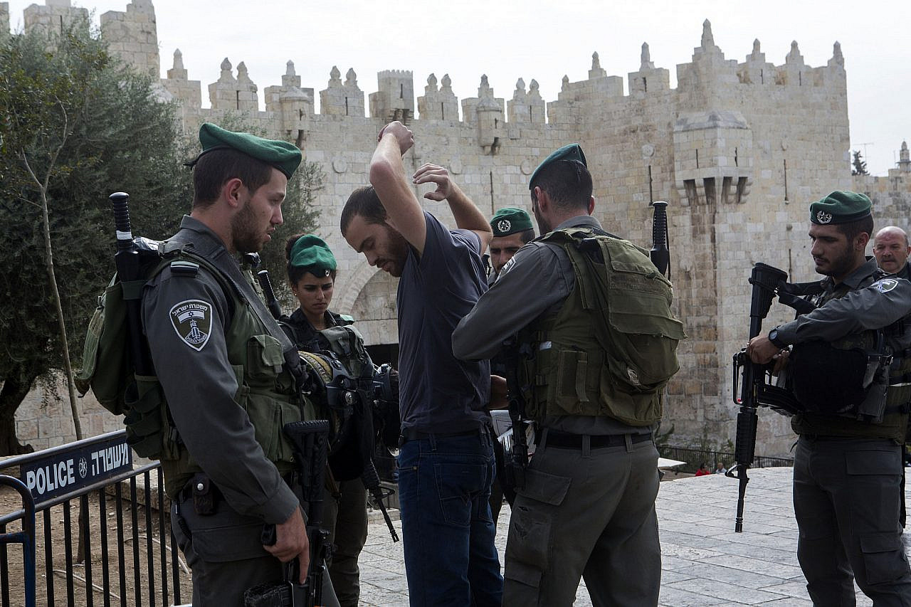 Israeli border police officers search a Palestinian man outside Damascus Gate, Old City of Jerusalem, October 23, 2015. (Anne Paq/Activestills)