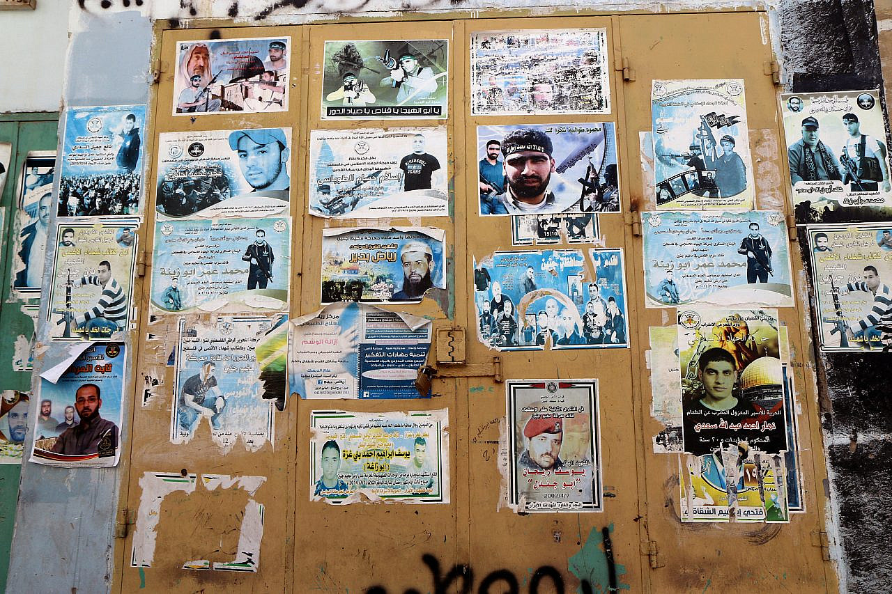 Posters of Palestinians killed by Israeli forces cover a door of a market store in Jenin refugee camp, occupied West Bank, March 8, 2015. (Activestills/Ahmad Al-Bazz)