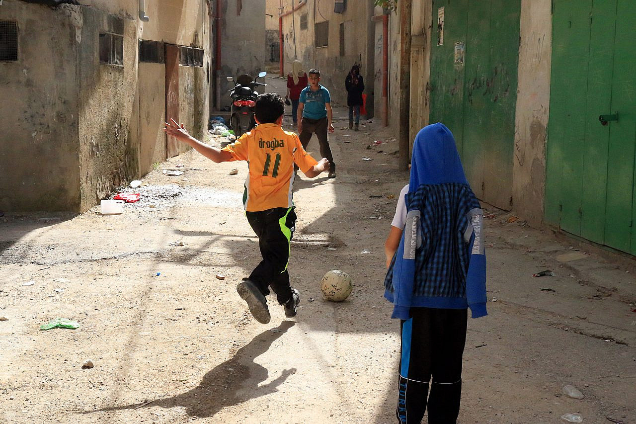 Palestinian children play football in Jenin refugee camp, occupied West Bank, March 8, 2015. (Activestills/Ahmad Al-Bazz)