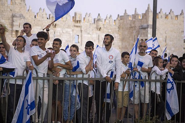 Young Orthodox Israelis wave flags during the annual Jerusalem Day Flag March outside Damascus Gate in Jerusalem's Old City, May 15, 2021. (Keren Manor/Activestills)