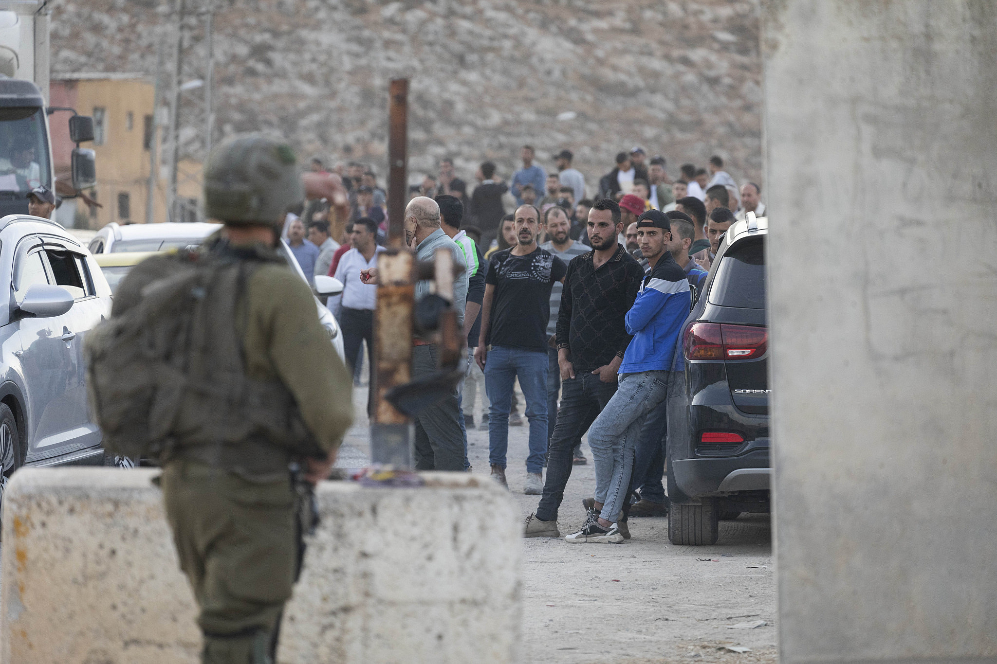 Palestinians line up at the Israeli military checkpoint of Beit Furik, east of Nablus, where strict inspection measures have been imposed recently, October 19, 2022. (Oren Ziv)