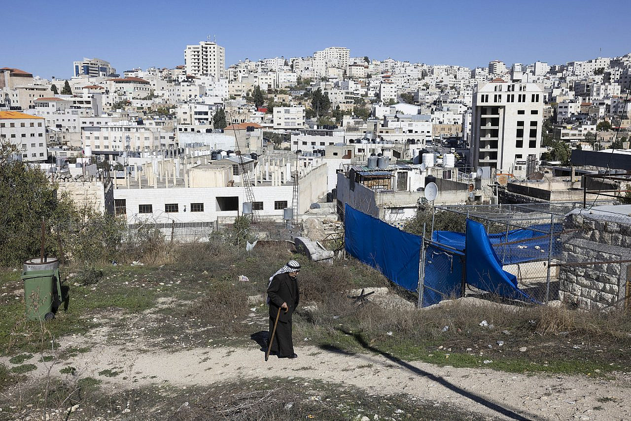 A Palestinian man walks through the neighborhood of Tel Rumeida, the day after a mass attack on the city's Palestinian community by settlers marking a religious occasion, Hebron, occupied West Bank, November 20, 2022. (Oren Ziv)