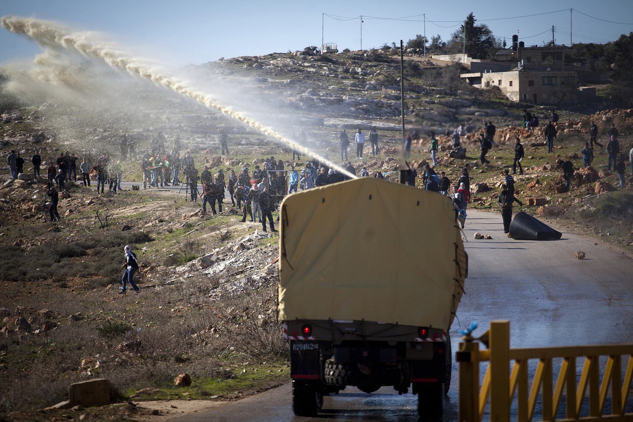 Israeli forces deploy the "Skunk Truck," a water cannon that shoots a powerful spray of foul-smelling chemicals, during protests following the funeral of Mustafa Tamimi in the West Bank village of Nabi Saleh, December 11, 2011. (Oren Ziv/Activestills)