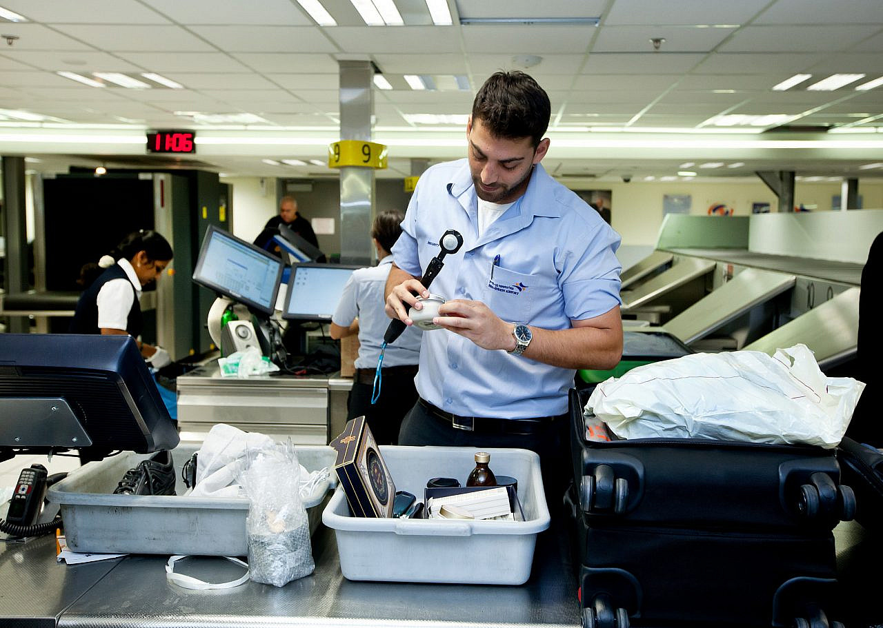 In this illustrative photo, a worker at Ben Gurion Airport checks passenger luggage, September 7, 2014. (Moshe Shai/Flash90)