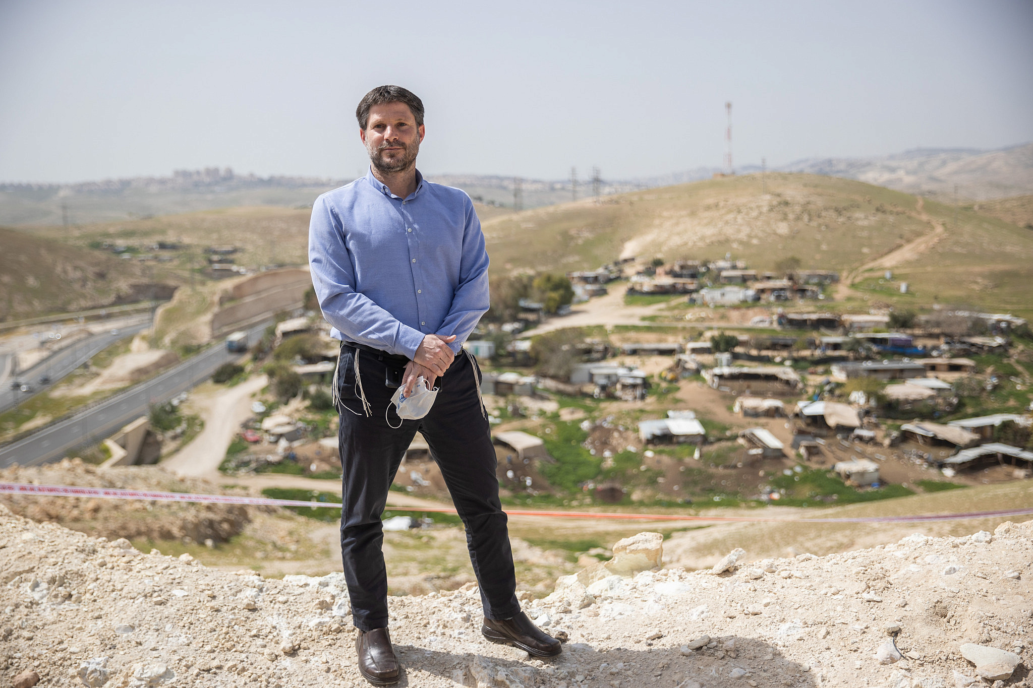 Religious Zionism Chairman Bezalel Smotrich stands above the Palestinian Bedouin village of Khan al-Ahmar, West Bank, March 21, 2021. (Yonatan Sindel/Flash90)