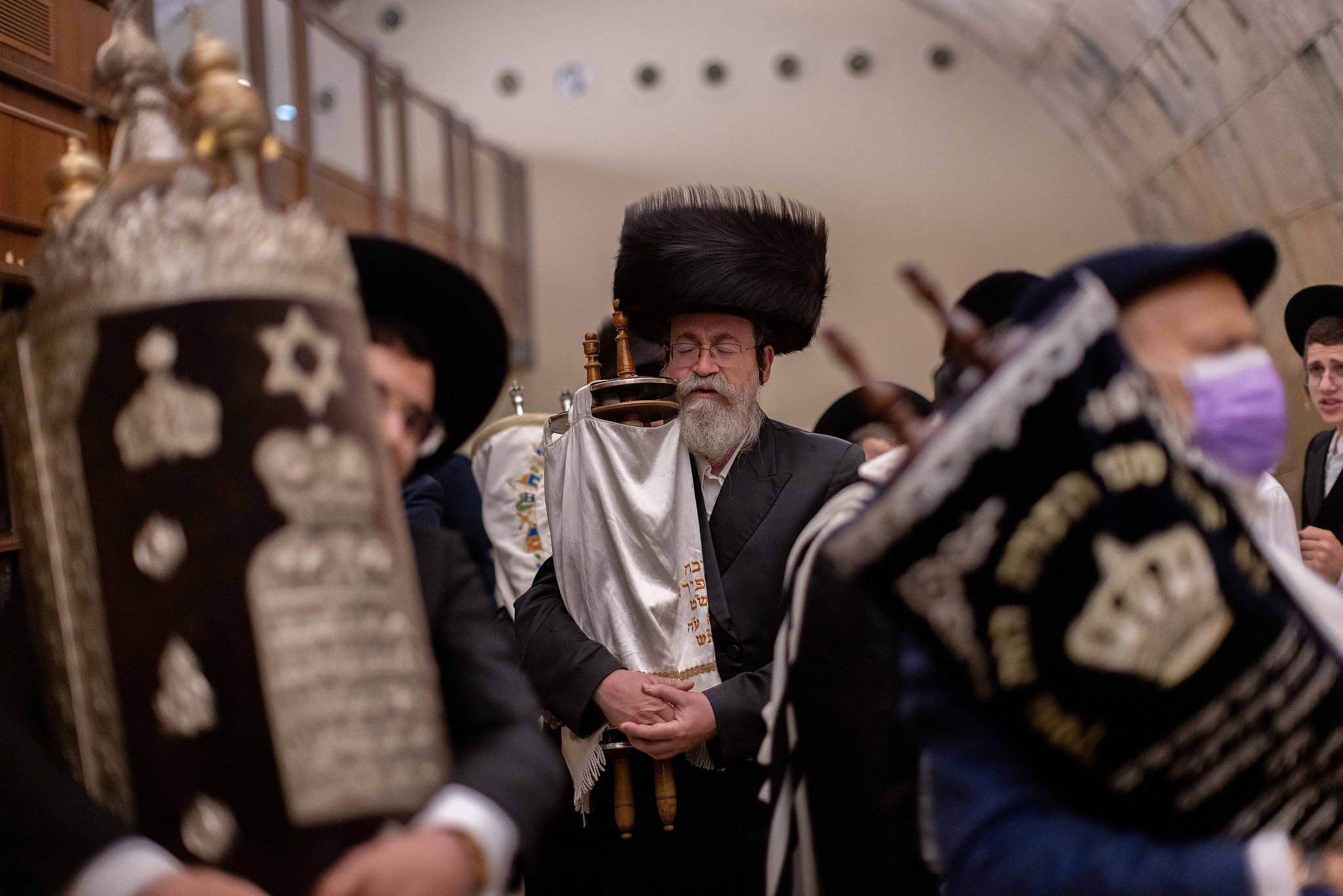 Jewish men carry Torah scrolls as they dance during Simchat Torah celebrations at the Western Wall in Jerusalem Old City, September 28, 2021. (Yonatan Sindel/Flash90)